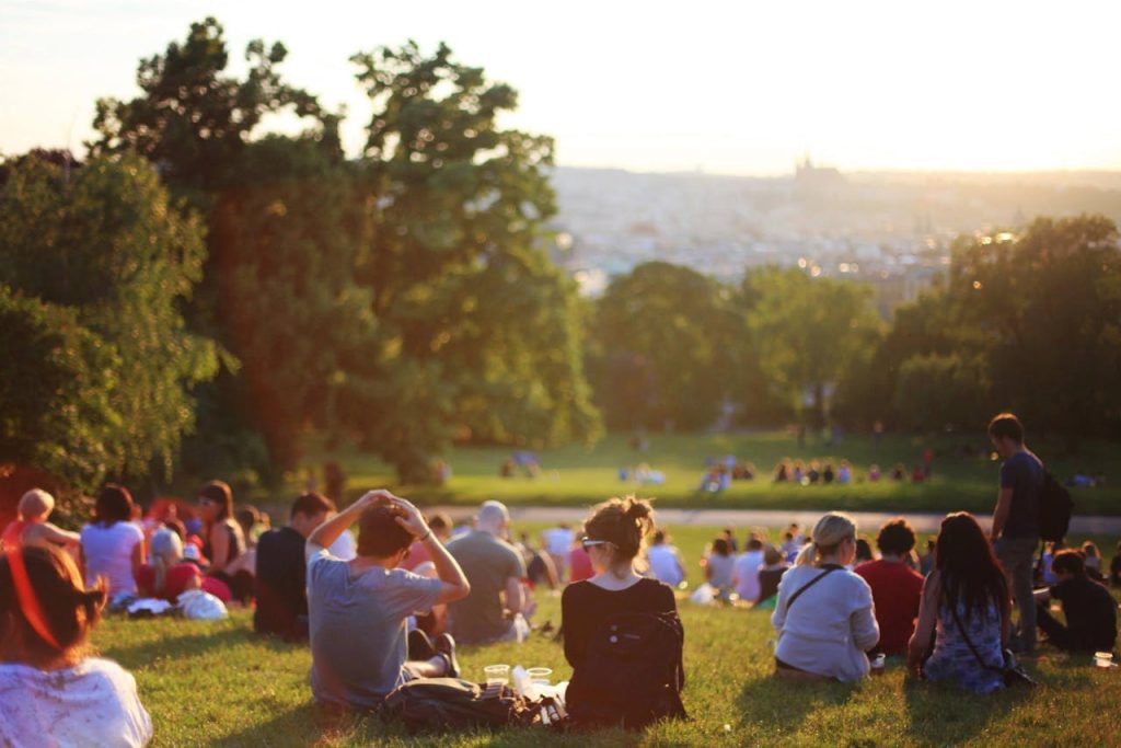 People relaxing and enjoying a sunny day in a bustling city park.